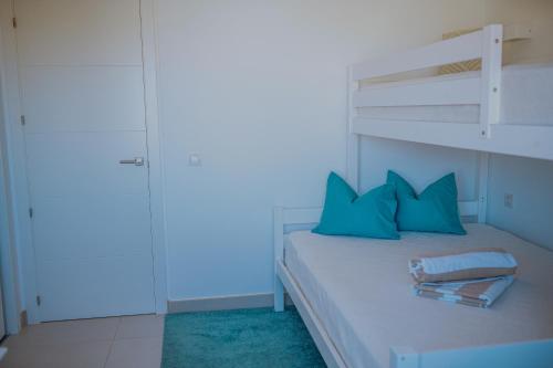 a bedroom with a bunk bed with blue pillows at Panorama Mar Apartment in Punta Prima