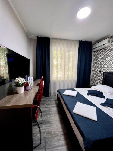 a hotel room with a bed and a desk and a bed and a table at Vila Iris in Chişinău