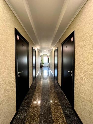 a hallway with black doors and a long corridor at Vila Iris in Chişinău