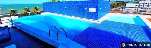 a large blue swimming pool on top of a building at Beira Mar Premium Apart - Solar do Atlântico Tambaú in João Pessoa
