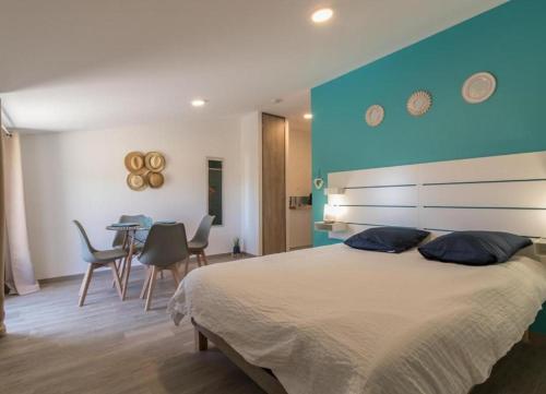 ein Schlafzimmer mit einem großen Bett mit blauer Wand in der Unterkunft Domaine le Caprougeat in Daux