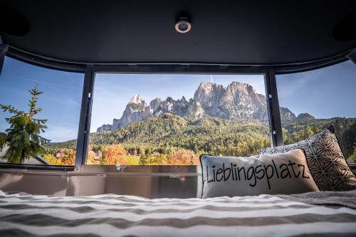a bedroom with a large window with a mountain view at Camping Seiser Alm in Völs am Schlern