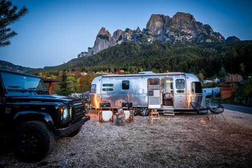 een camper en een truck geparkeerd naast een trailer bij Camping Seiser Alm in Fiè