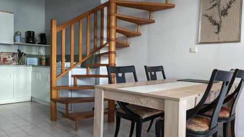 a dining room table with chairs and a staircase at Les tourelles in Dieppe