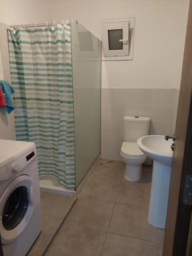 a bathroom with a washing machine and a toilet at White house 3 bedroom City Center in Limassol