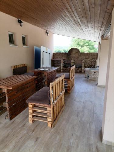 a large room with wooden furniture and a large window at Jázmin Vendégház in Nyírlövő