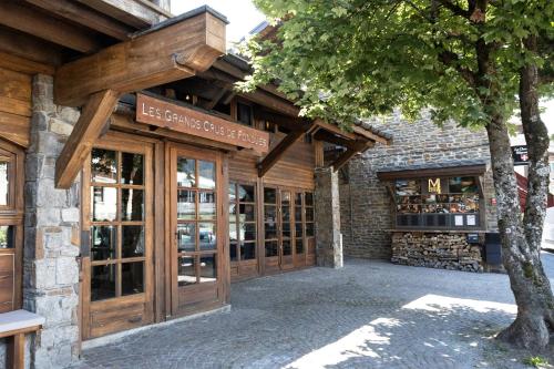 a store front with wooden doors and a tree at M de Megève in Megève