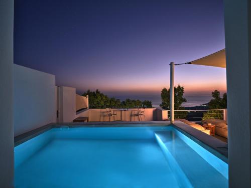 a swimming pool in a house with a sunset at Santorini Heights in Pirgos
