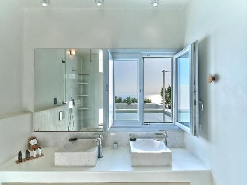 a bathroom with two sinks and a large window at Santorini Heights in Pirgos