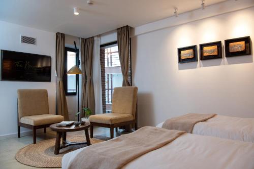 Habitación de hotel con 2 camas, mesa y sillas en The Nanee, en Bhaktapur