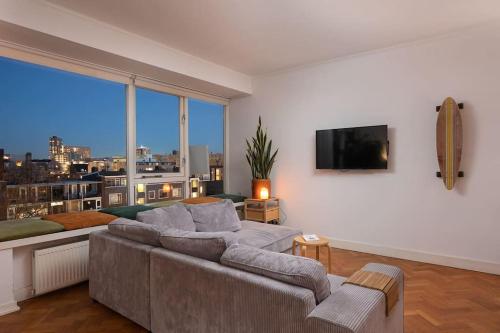 a living room with a couch and a flat screen tv at Cozy Stay Rotterdam City in Rotterdam