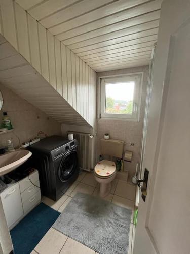 a small bathroom with a toilet and a washing machine at Apartment Gartenblick in Alsdorf