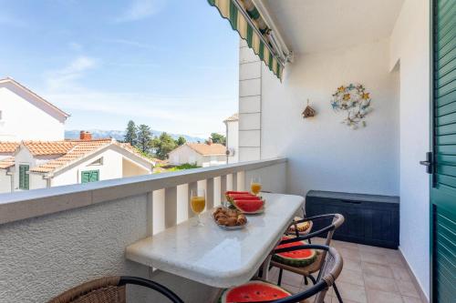 un balcón con una mesa con comida y bebidas. en Apartment Zara Supetar, en Supetar