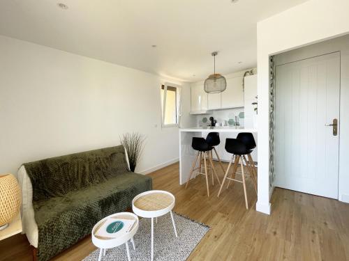 a living room with a couch and a table at Au pied des dunes in Seignosse