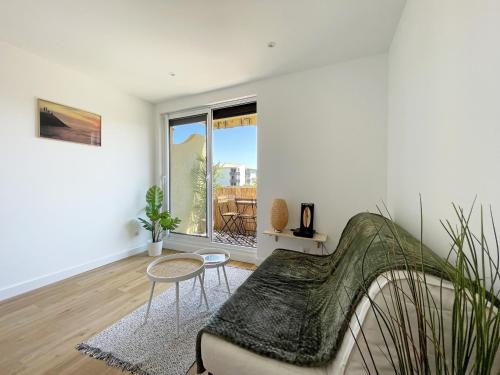 un salon avec un canapé et une fenêtre dans l'établissement Au pied des dunes, à Seignosse