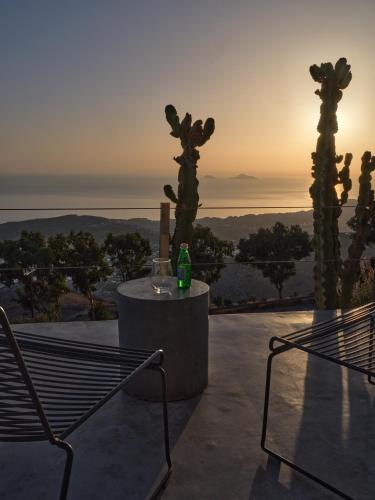 a table and chairs on a patio with the sunset at Santorini Heights in Pirgos