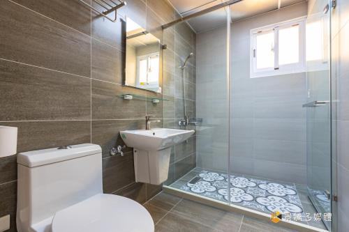 a bathroom with a toilet and a sink and a shower at Tie Zhi Road B&B in Taitung City