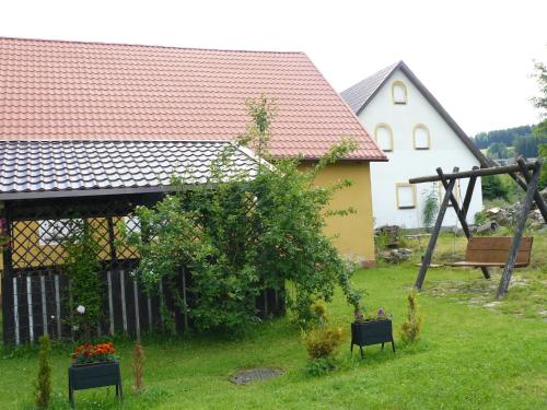 a house with a garden with flowers in a yard at STANICA in Nowy Gierałtów