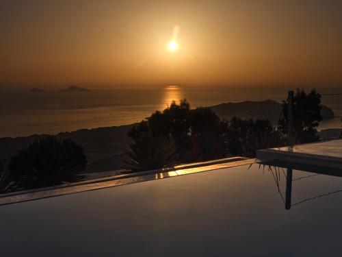 a view of the sun setting over the ocean at Santorini Heights in Pirgos