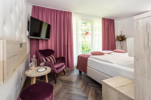 um quarto de hotel com duas camas e uma televisão em Boutiquehotel Bergvilla em Dafins