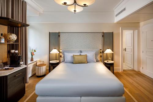 a bedroom with a large white bed with two lamps at Small Luxury Hotel Ambassador Zurich in Zurich