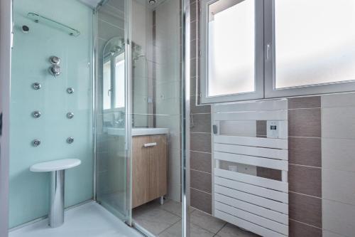 uma casa de banho com um chuveiro e um lavatório. em Le Célesthémy em Cornimont