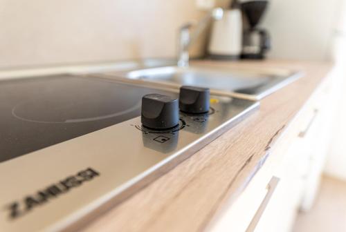 a kitchen counter with two black knobs on a stove at Apartments Crneković III in Baška