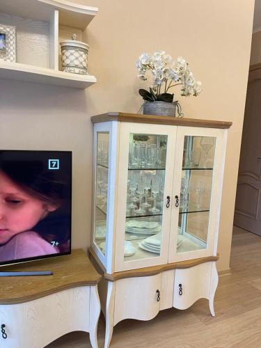 um armário com uma televisão numa sala de estar em Dzintari em Jūrmala
