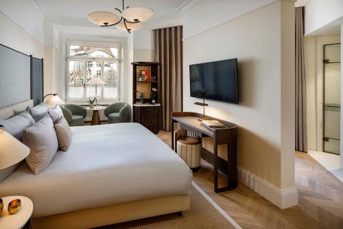 a hotel room with a bed and a television at Small Luxury Hotel Ambassador Zurich in Zurich