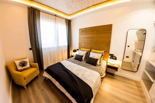 una camera con letto, sedia e specchio di Zabella Salamero Espectacular atico en el centro a Saragozza