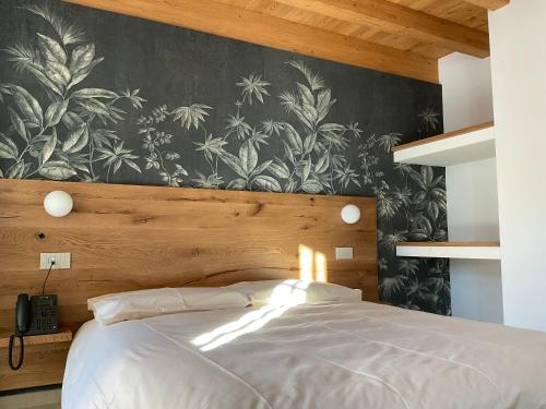 a bedroom with a white bed with a wall mural at Garni La Casetta in Livigno
