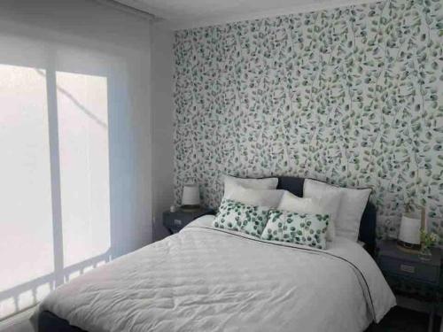 1 dormitorio con 1 cama y papel pintado con motivos florales en Casa dos Alén, en Ourense