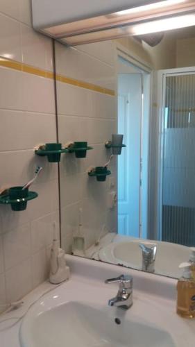 une salle de bain avec un lavabo et un grand miroir dans l'établissement exceptionnel penthouse vue mer, à Wimereux