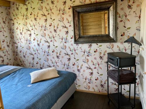 a bedroom with a bed and a mirror on the wall at Landelijk gelegen houten huisje in Opperdoes