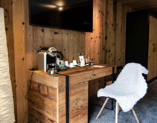 a room with a wooden table and a chair at M de Megève in Megève