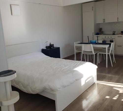 1 dormitorio con cama blanca y mesa con sillas en La terrazza, en Molfetta