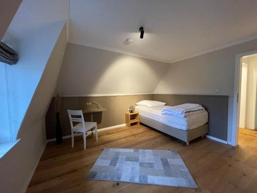 a bedroom with a bed and a table and a chair at Hus Boompecker in Achtrup