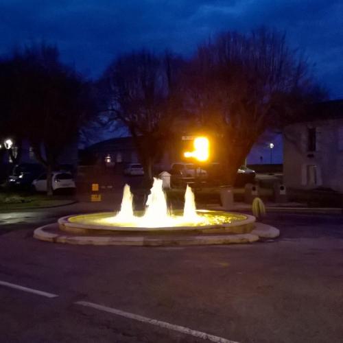 a fountain in the middle of a street at night at Gîte de Claire in Lectoure