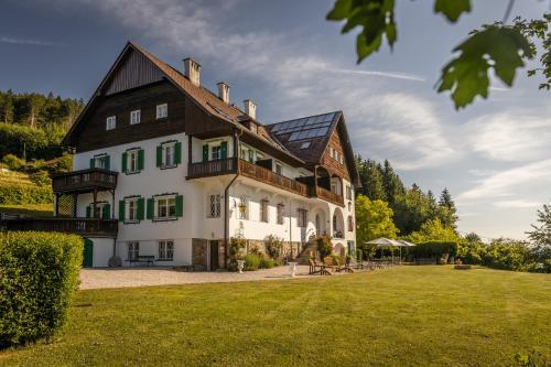 a large house with green shutters on a yard at Villa Weiss in Attersee am Attersee