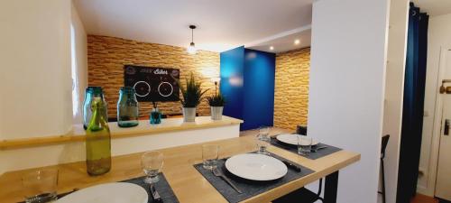 een eettafel met twee witte borden en wijnglazen bij Zen Studio Le Granier Challes Centre - Parking in Challes-les-Eaux