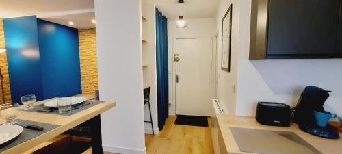 a kitchen with a table and a sink in a room at Zen Studio Le Granier Challes Centre - Parking in Challes-les-Eaux