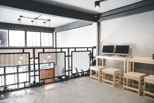 a room with tables and chairs and a large window at The Cube Hostel Khaosan in Bangkok