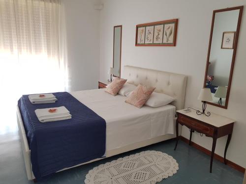 a bedroom with a bed with a mirror and a table at Appartamento Raggio Di Sole in Acireale