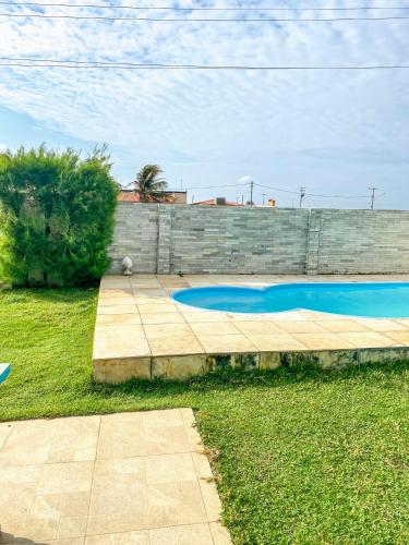a swimming pool in a yard next to a brick wall at Casa Rústica em Morro Branco - na quadra da praia in #N/A