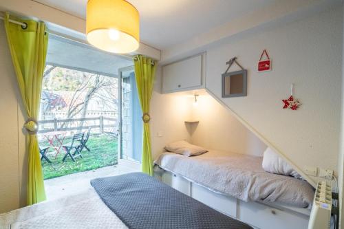 a room with two beds and a staircase with a window at LAtiPic in Barèges