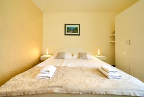 a bedroom with a bed with two towels on it at Apartments ROYAL in Kornić