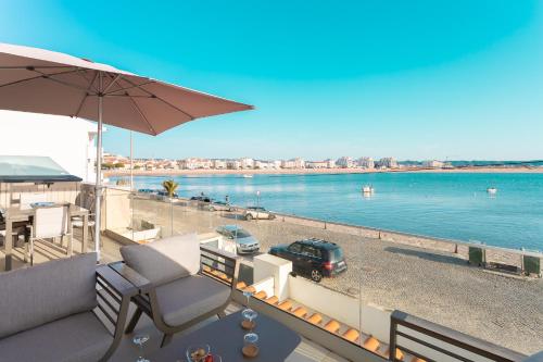 a balcony with an umbrella and a car on the water at Paradise bay T3 - by Smarthomes in São Martinho do Porto