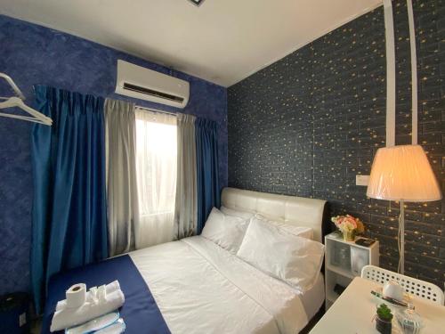 a bedroom with a bed and a table with a lamp at SBS HOTEL in Padang Besar