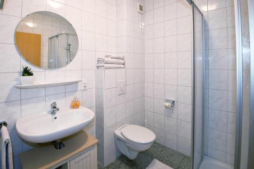 a bathroom with a toilet and a sink and a shower at Ferienwohnung Jacobs EG in Norddeich