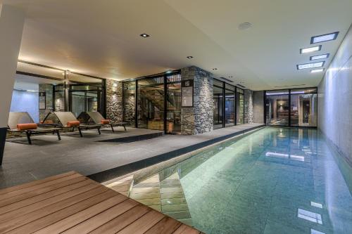 an indoor swimming pool in a house with a building at M de Megève in Megève